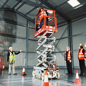 Scissor lift working in warehouse